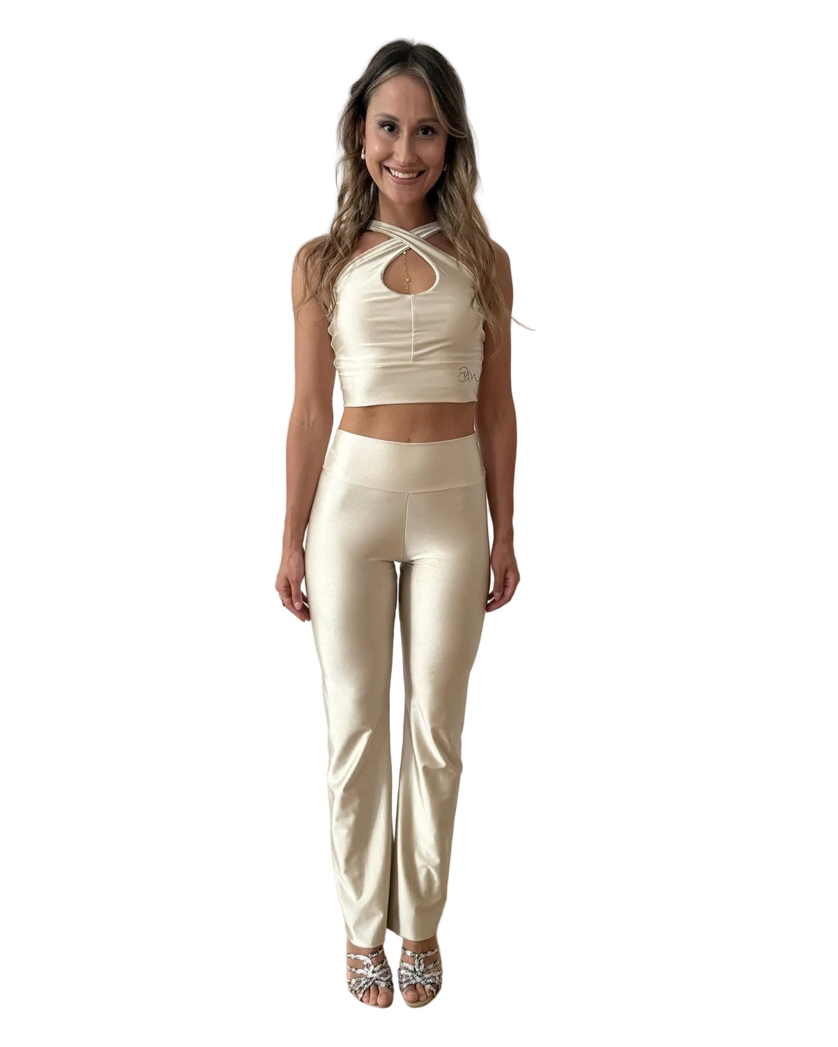 A woman modeling a matching two-piece satin-like BACHATA DANCEWEAR Set consisting of a cream halter crop top with front cutouts and high-waisted straight-leg pants, 