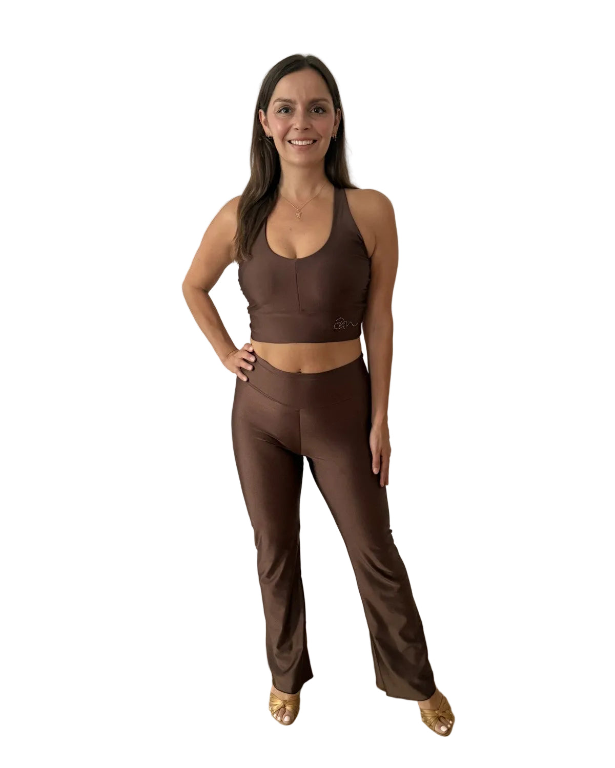 A woman modeling a matching brown activewear set consisting of a sports bra and high-waisted flared leggings