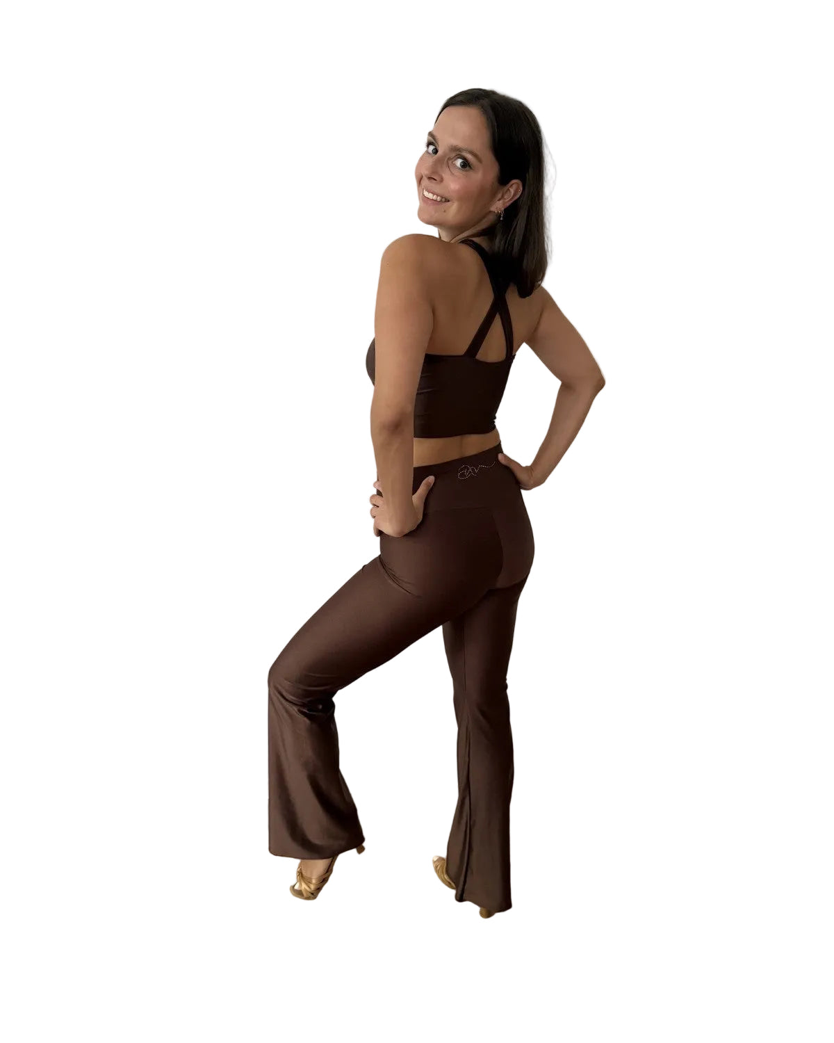 A woman modeling a matching dark brown two-piece dance set consisting of a strappy halter crop top and high-waisted flared pants ama move